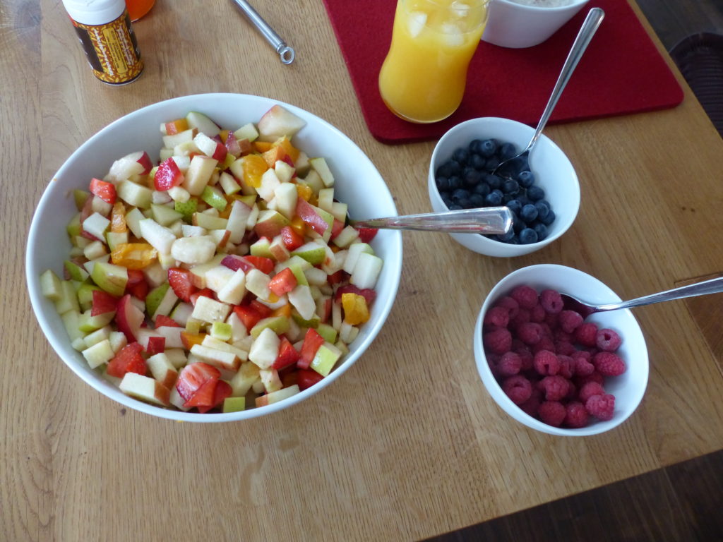 Obstsalat und Beeren als Beilage zum Porridge